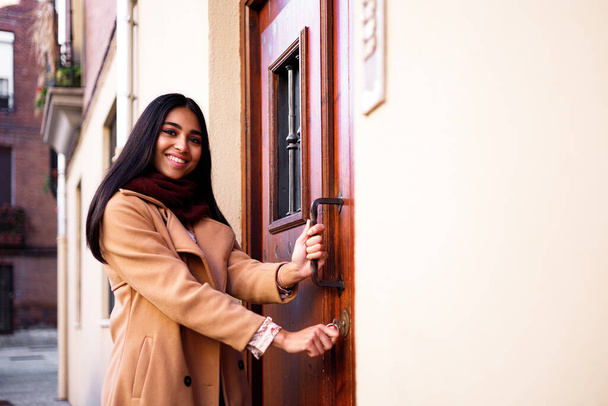 feliz bela mulher indiana abrindo sua porta de casa e olhando para thte câmera, espaço de cópia - Foto, Imagem