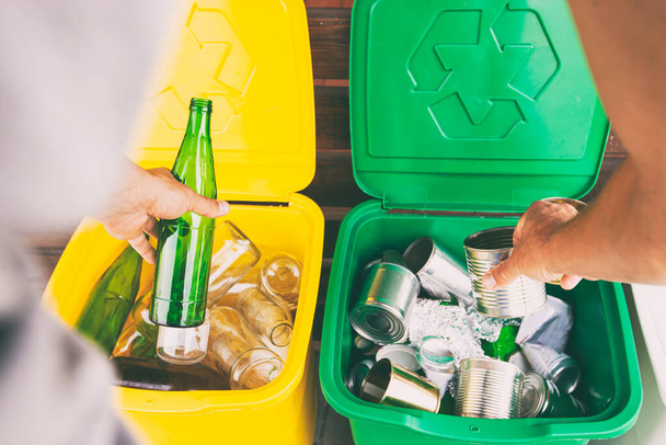 Man throwing the glass bottle andtin can into differennt dustbins for sorting trash - Φωτογραφία, εικόνα