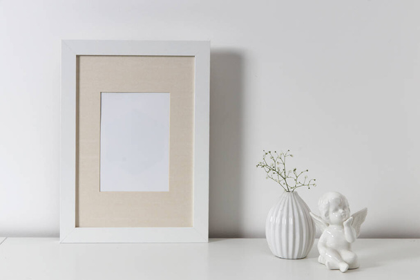 Blank canvas frame mockup. Artwork in interior design. View of modern scandinavian style interior with canvas for painting or poster on wall. Living room, commode with vases. Minimalism concept - Zdjęcie, obraz