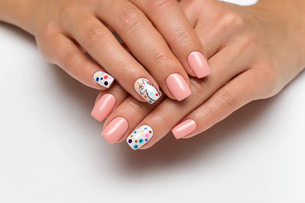 gyengéd rózsaszín manikűr festett egyszarvú ujjak és konfetti szögletes körmök fehér háttér - Fotó, kép