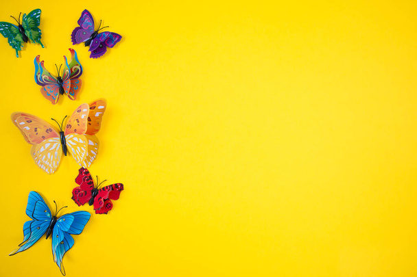 Dekorative Schmetterlinge auf leuchtend gelbem Hintergrund. Das Konzept der Frühling-Sommer-Saison. - Foto, Bild