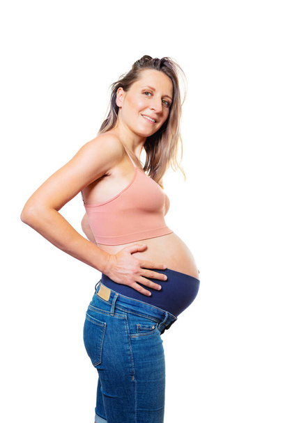 Pregnant woman holing big belly standing isolated on white focus on waist profile view - Φωτογραφία, εικόνα