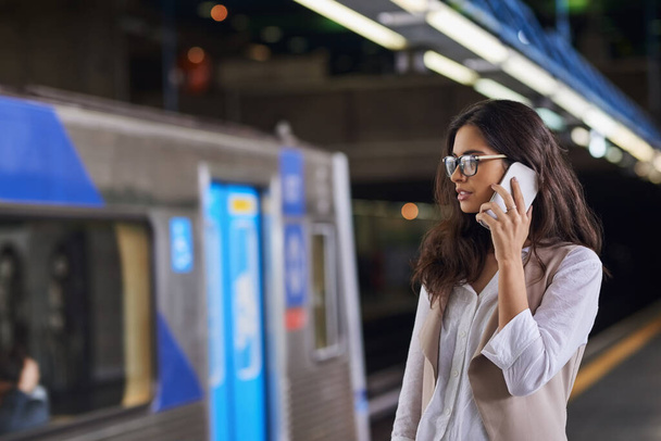 On the move and on the call. Cropped shot of a young attractive woman on a call and using the train to commute. - Foto, imagen