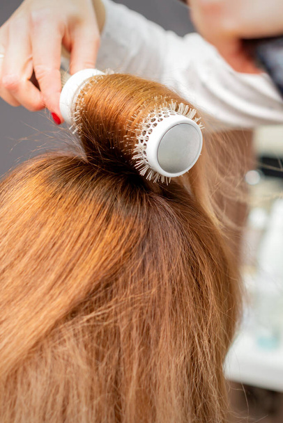 Secado de cabello rojo con secador de pelo y cepillo redondo, de cerca - Foto, Imagen