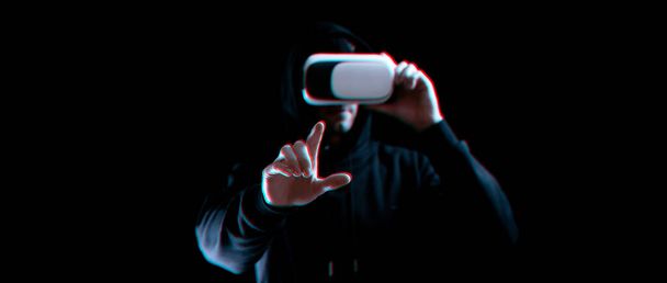 仮想現実ゲームvr.不具合の影響で暗い背景に仮想現実技術のためのデジタルメガネの青い若い男。3Dシミュレーションでの学習と仮想世界 - 写真・画像