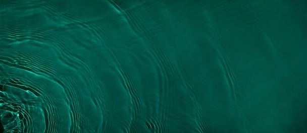 transparant donkergroen gekleurd helder kalm wateroppervlak textuur  - Foto, afbeelding