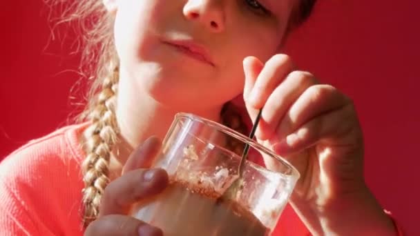 Kind isst Joghurtgelee rosa Hintergrund. Milchprodukte Diät Lactobacillus Acidophilus, gesundes hausgemachtes Frühstücksmenü. Kindergesundheit. Veganes Essen Nussmilch Gelatine ohne Milchprodukte Dessert Proteinpudding - Filmmaterial, Video
