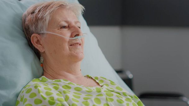 Κοντινό πλάνο συνταξιούχου ασθενούς με ασθένεια που έχει ρινικό σωλήνα οξυγόνου - Φωτογραφία, εικόνα