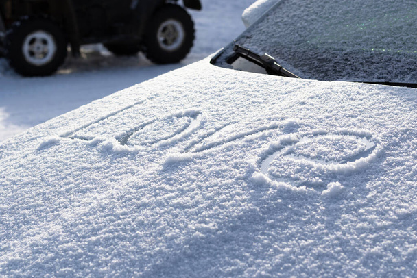 雪の碑文は、大きな文字で車のフードカバー晴れた冬の日に愛。選択的フォーカス。閉鎖 - 写真・画像