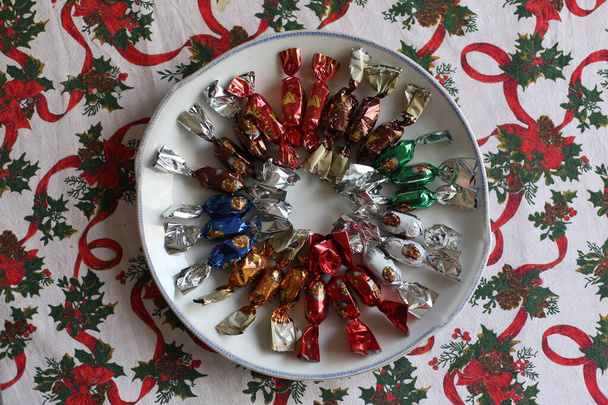 Egy csomó magyar karácsonyi fondant karácsonykor az asztalon. Csoportja szalon cukorka egy tál színes asztalterítő természetes háttér. Eredeti karácsonyi édesség Magyarországról név szaloncukor - Fotó, kép