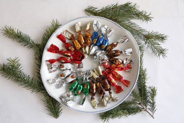 Куча венгерских рождественских помазок на рождественском столе. Группа конфет в миске на красочном скатерти природного фона. Оригинальное венгерское название - Faloncukor - Фото, изображение