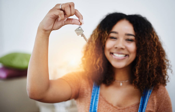 Proper start of adulthood. Cropped shot of a beautiful young woman holding house keys in her new home. - Fotó, kép