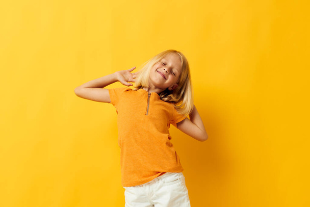 Little girl smile hand gestures posing casual wear fun yellow background unaltered - Foto, afbeelding