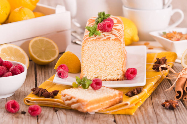 Lemon sponge cake with raspberies on white dish. - Foto, Imagen