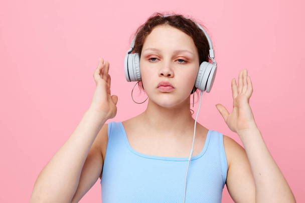 cute girl wearing headphones stylish youth clothing pink background - Foto, Imagen