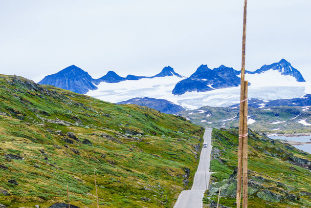 Camper car drive on asphalt road in norwegian mountains, Sognefjellet tourist route, Norway - 写真・画像
