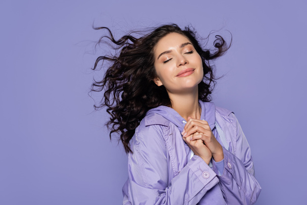 happy young woman with closed eyes and clenched hands isolated on purple - Photo, Image