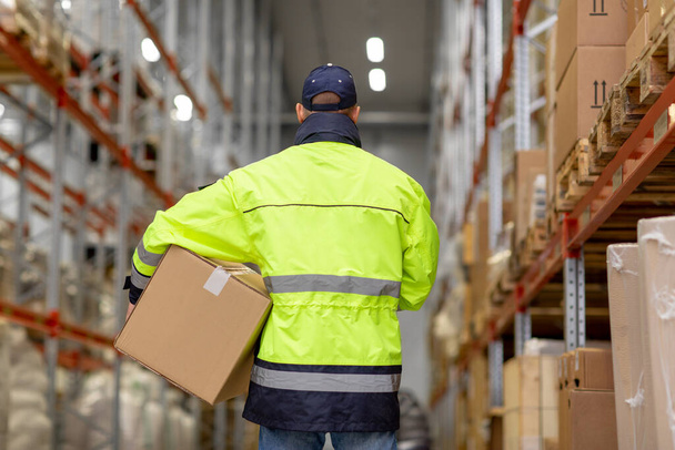 man in uniform with box at warehouse - Foto, Bild