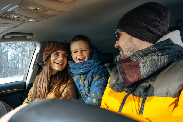 Mother, father and child traveling by car on a vacation to the mountains in winter - Photo, image
