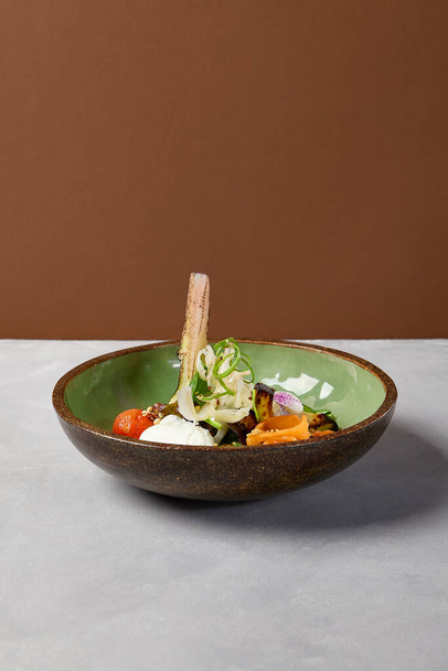 Salad bowl with salmon, avocado, broccoli, vegetables and egg on homemade ceramic plate. Buddha bowl with salmon, broccoli, quinoa in modern serveware. Modern ceramic dishware on concrete background - Fotoğraf, Görsel