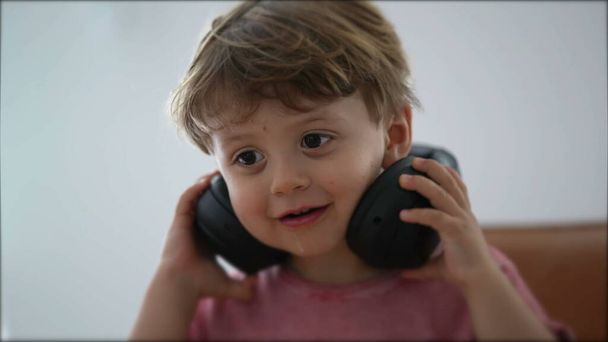 Lapsi poistaa kuulokkeet korvasta lapsi ottaa pois kuulokkeet - Valokuva, kuva