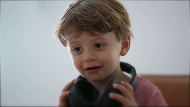 Child removing headphones from ear kid taking takes off headphones - Photo, Image