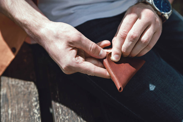 Leather coin holder in in mens hands close-up - 写真・画像