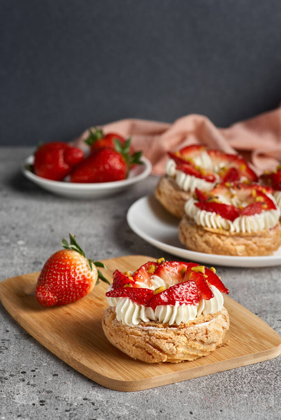 Choux pastries. Craquelin Choux biscuits. crispy cream puffs with cream filling and Strawberries. - Zdjęcie, obraz