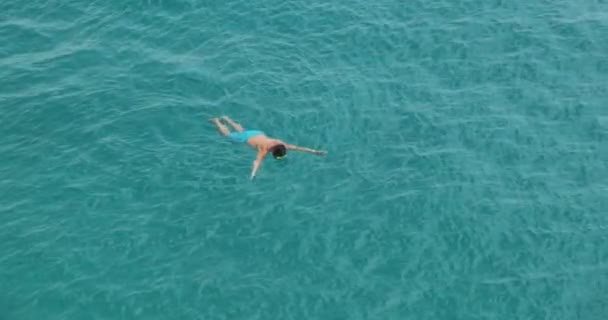 Biały mężczyzna pływa z maską w czystej, przezroczystej turkusowej wodzie w morzu. Widok z góry, nurkowanie, średni strzał, zwolnione tempo - Materiał filmowy, wideo