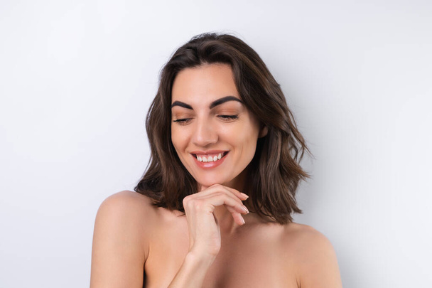 Κοντινό πορτρέτο ομορφιάς μιας γυμνόστηθης γυναίκας με τέλειο δέρμα και φυσικό μακιγιάζ - Φωτογραφία, εικόνα