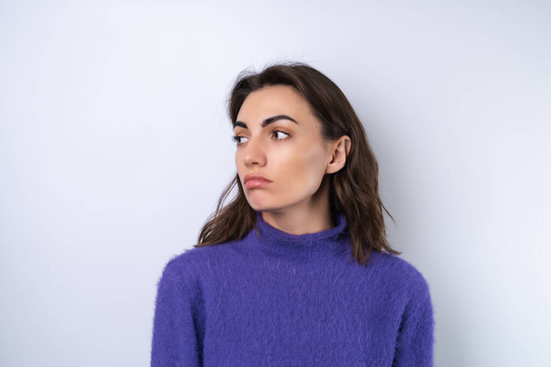 Mujer joven en púrpura suave suéter acogedor en el fondo molesto - Foto, imagen