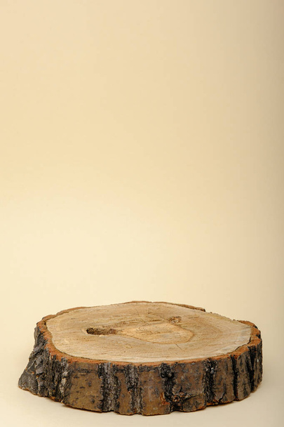 vertikal ein rundes Holzpodest oder Plattform auf beigem Hintergrund, Vitrine für Öko-Kosmetikprodukte, Kopierraum - Foto, Bild