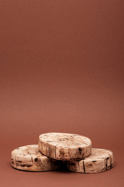 függőleges három kerek fűrészlap vagy fa dobogó öko kozmetikumok barna alapon történő bemutatásához, másoló tér - Fotó, kép