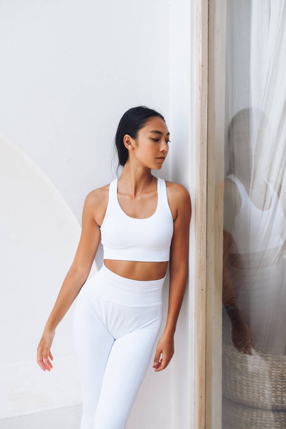 Modelo asiático de Fitnes aparência esporte na moda sportswear posando sobre a parede branca - Foto, Imagem