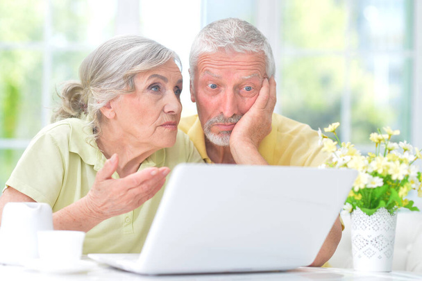 confused  senior couple with laptop at home - Foto, Imagem