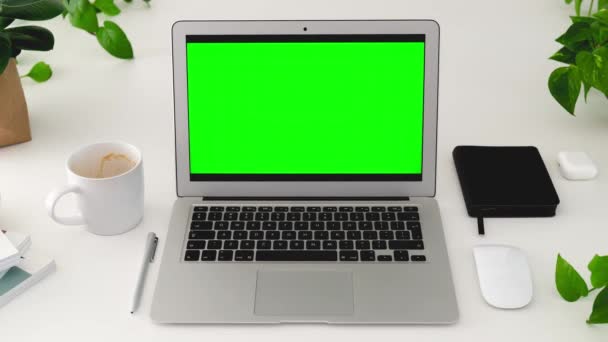 Notebook s modelem-up zelené obrazovky na bílém stole s domácími rostlinami v kanceláři. Biofilní koncept interiéru a propojení s přírodním konceptem. Zastavit animaci pohybu. - Záběry, video