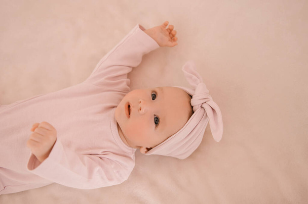 Cute newborn smiling girl on a light background - Photo, Image