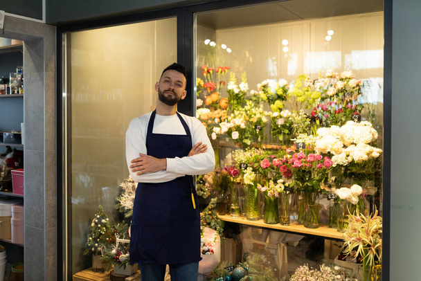 the owner of the flower warehouse next to the refrigerator with fresh bouquets - Photo, Image