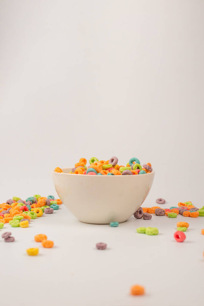 Colorful cereal box for morning breakfast. Corn flakes falling to the white bowl. Motion. Copyspace. - Foto, afbeelding
