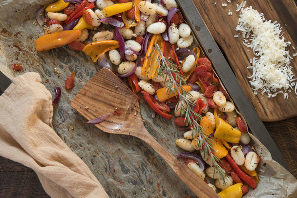Gebakken gnocchi en groenten met verse geraspte parmezaanse kaas en rozemarijn. - Foto, afbeelding