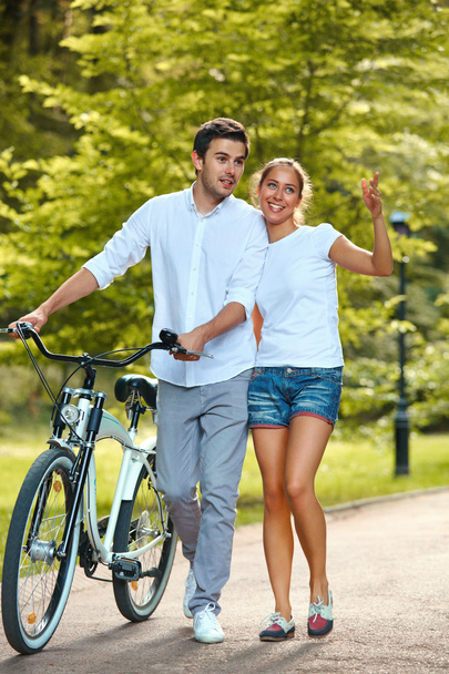 公園で自転車と幸せなカップル. - 写真・画像
