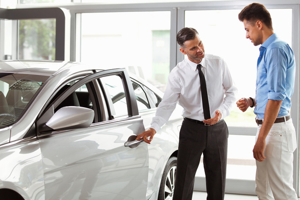 Vehicle Dealer Showing Young Man New Car - 写真・画像