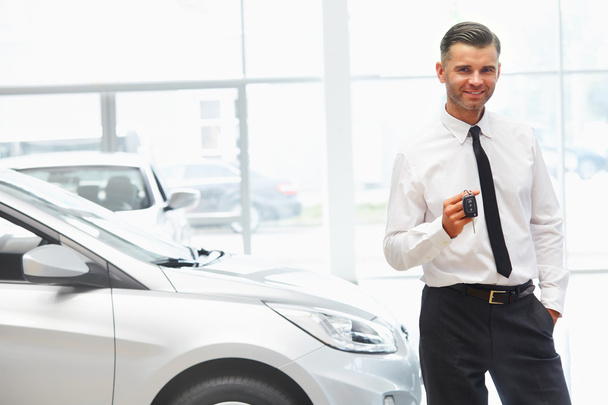 Car Salesman Giving Key of New Car - Фото, изображение