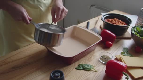 vrouw zet saus in ovenware - Video