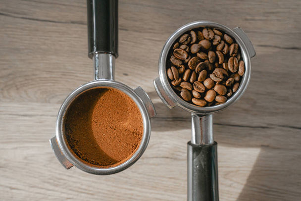 ground coffee is tempered in the holder, the coffee bean lies in the holder, on a wooden table, top view, the process of preparing a coffee drink - Foto, imagen