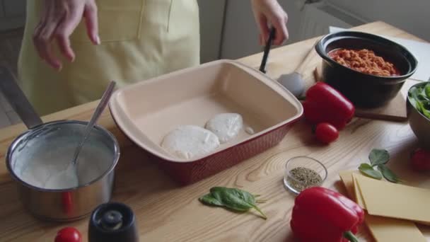 Cook sta mettendo la salsa bianca nel forno - Filmati, video
