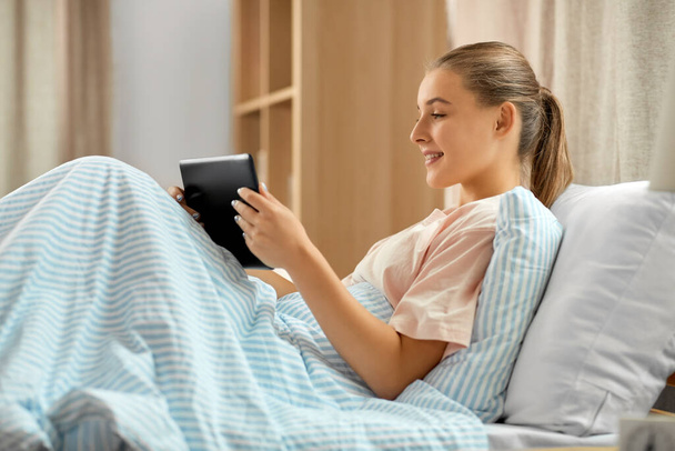 happy girl with tablet pc computer in bed at home - Φωτογραφία, εικόνα
