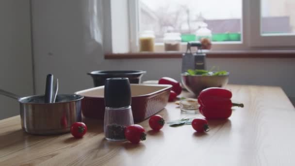 Ingredientes y cosas de la cocina están acostados en la mesa - Imágenes, Vídeo