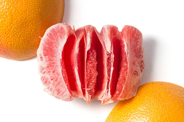 Frisches rotes Grapefruitfleisch und Schale isoliert auf weißem Hintergrund von oben. Geschälte Zitrusfrüchte Hintergrundansicht. Gesunde Ernährung, Vitamin C-Konzepte - Foto, Bild