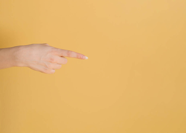 Το θηλυκό χέρι δείχνει ένα δάχτυλο προς το χώρο αντιγραφής. - Φωτογραφία, εικόνα